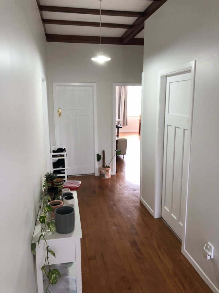 Renovated hallway with wooden floors white walls