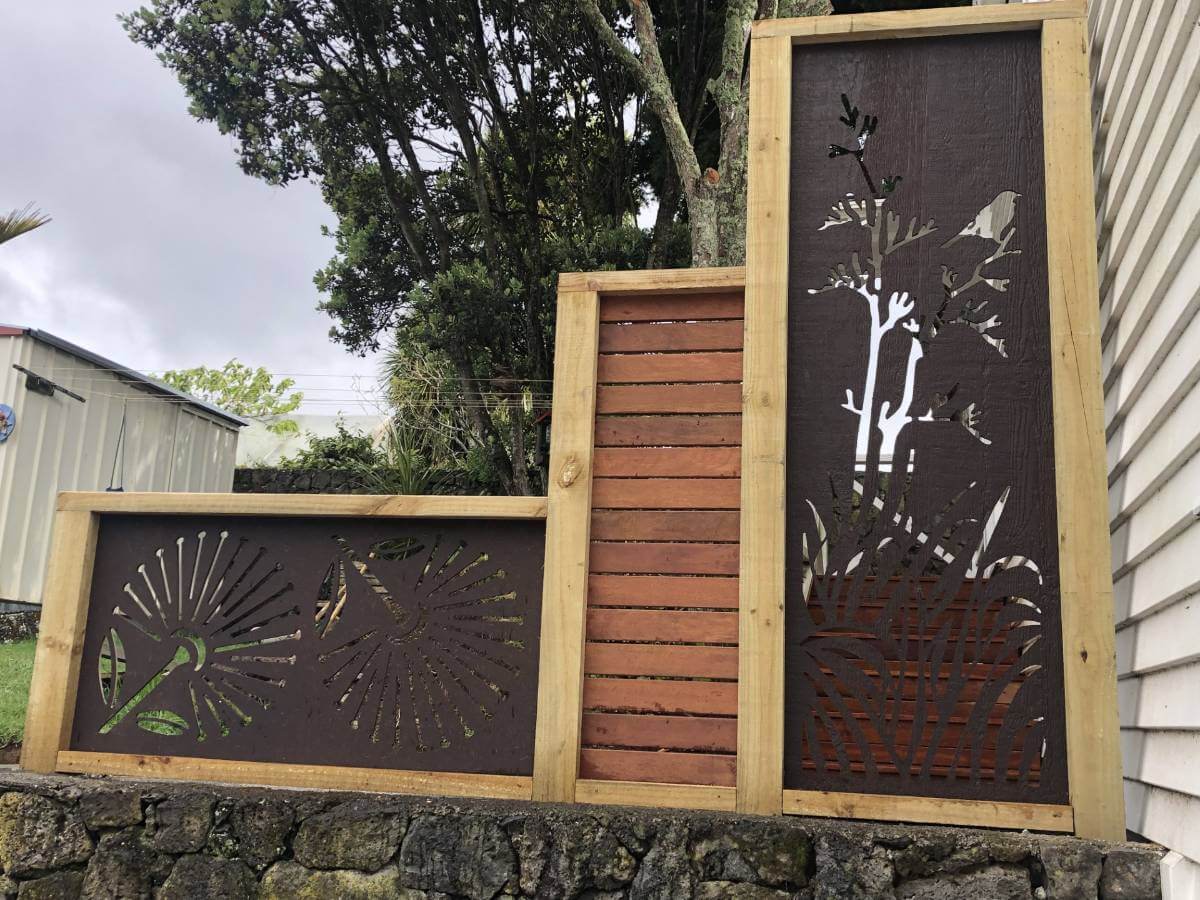 Decorative screening for house with cutout flax, tui and pohutakawa