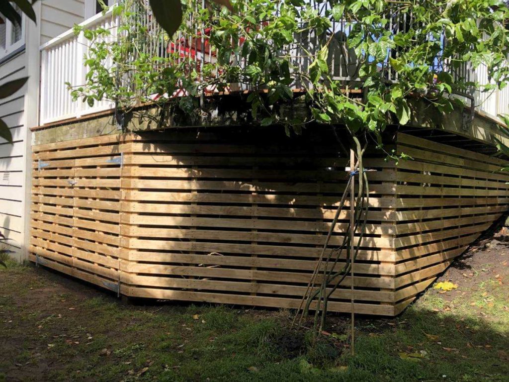 Wooden screening under a deck with rubbish bin storage